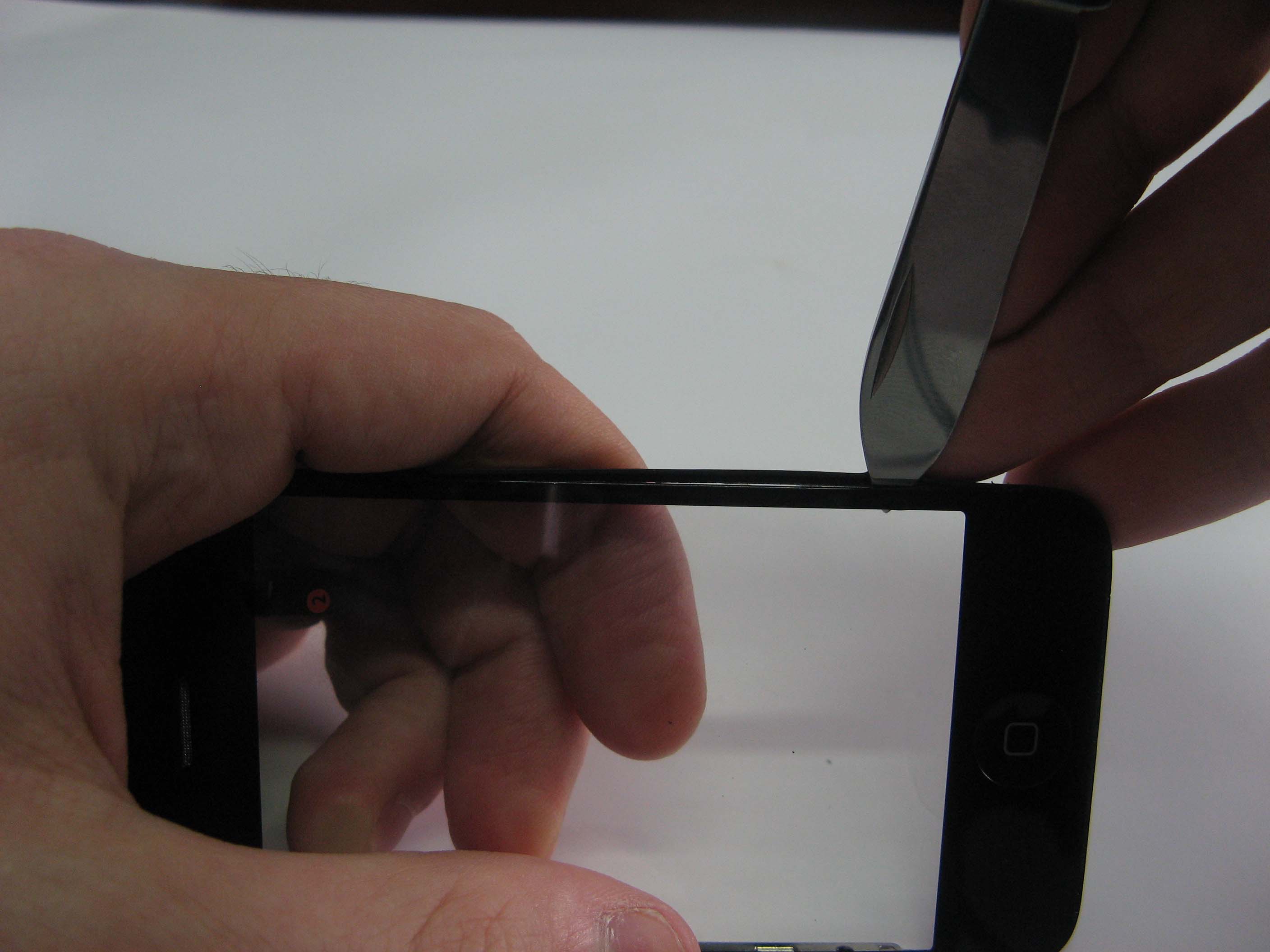 Помогаем ножиком в отсоединении рамки iPhone 3G